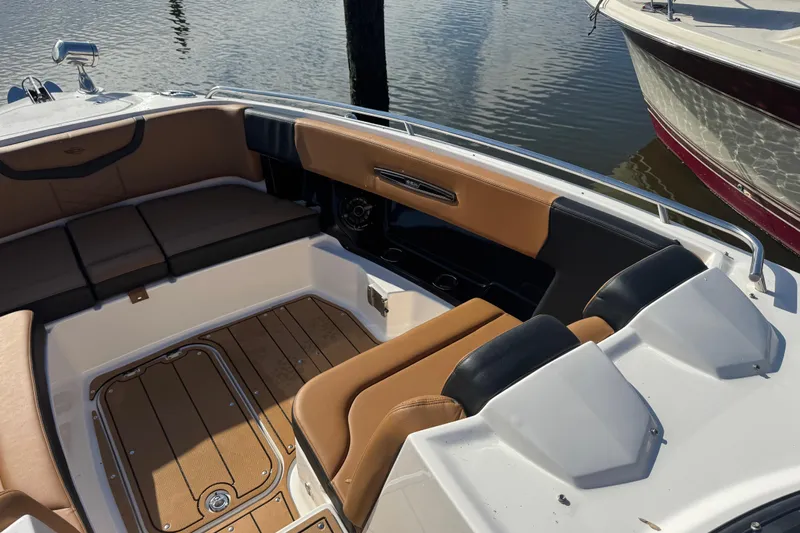  Yacht Photos Pics 2023 Chaparral 347 SSX boat interior with tan and black seating, docked by water.