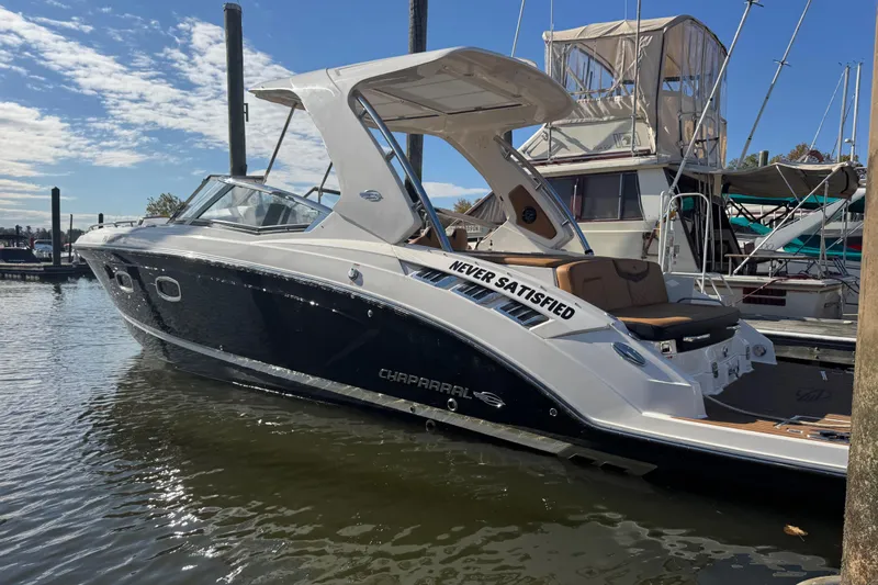  Yacht Photos Pics 2023 Chaparral 347 SSX boat docked, featuring sleek design and "Never Satisfied" decal.