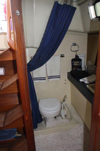 1986 Pearson 36-2 yacht bathroom with blue curtain and compact toilet.