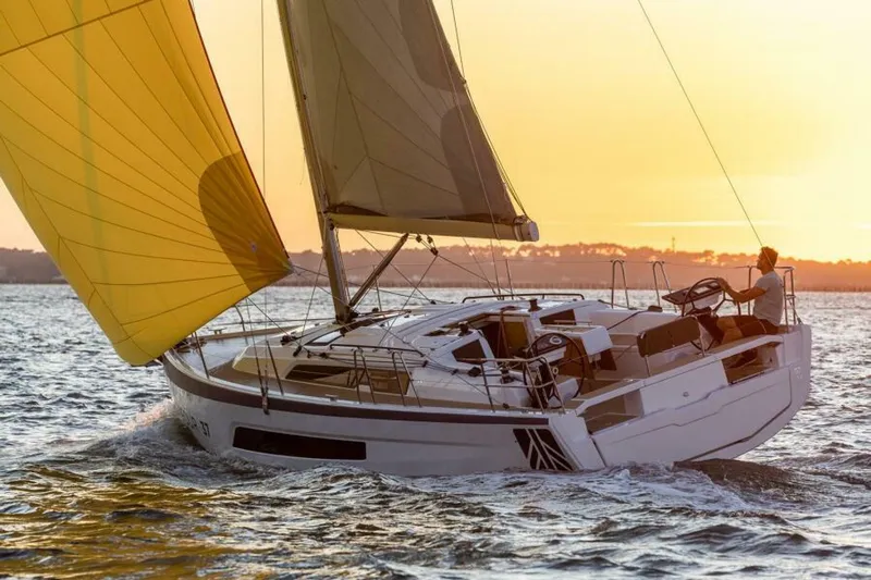 In Stock #108 Yacht Photos Pics 2025 Dufour 37 sailboat with yellow sail at sunset on the water.