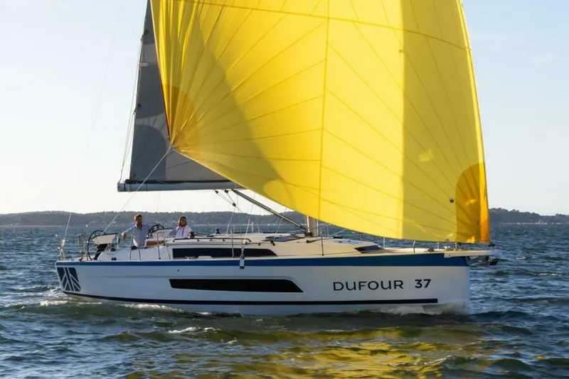 In Stock #108 Yacht Photos Pics 2025 Dufour 37 sailboat with a vibrant yellow sail on open water.