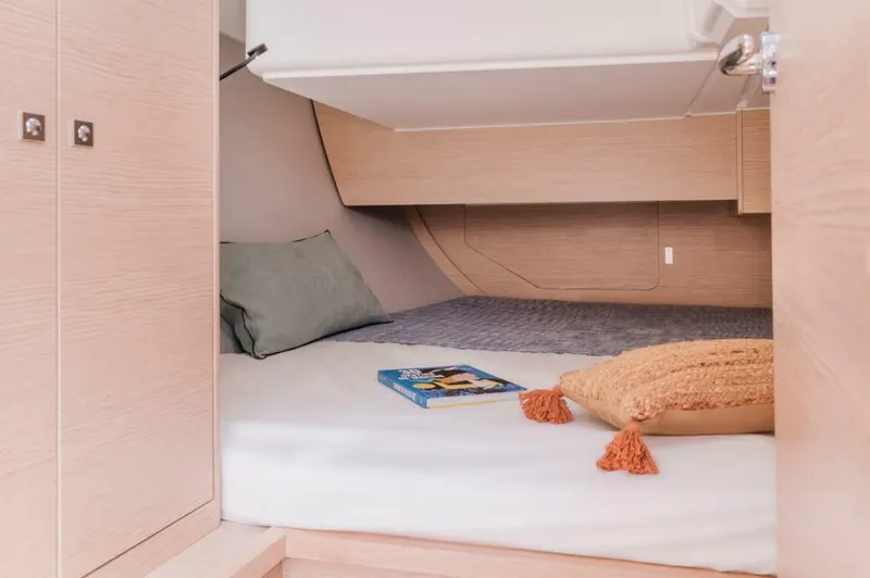 In Stock #108 Yacht Photos Pics Cozy cabin interior of 2025 Dufour 37 yacht with pillows and a book.