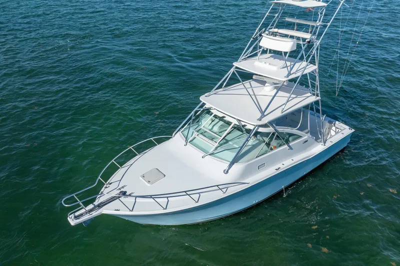 Reel Steel Yacht Photos Pics 2004 Cabo 35 Express boat on clear blue water, featuring a sleek design and spacious deck.