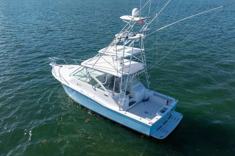 Reel Steel Yacht Photos Pics 2004 Cabo 35 Express boat on open water, featuring a sleek design and fishing equipment.