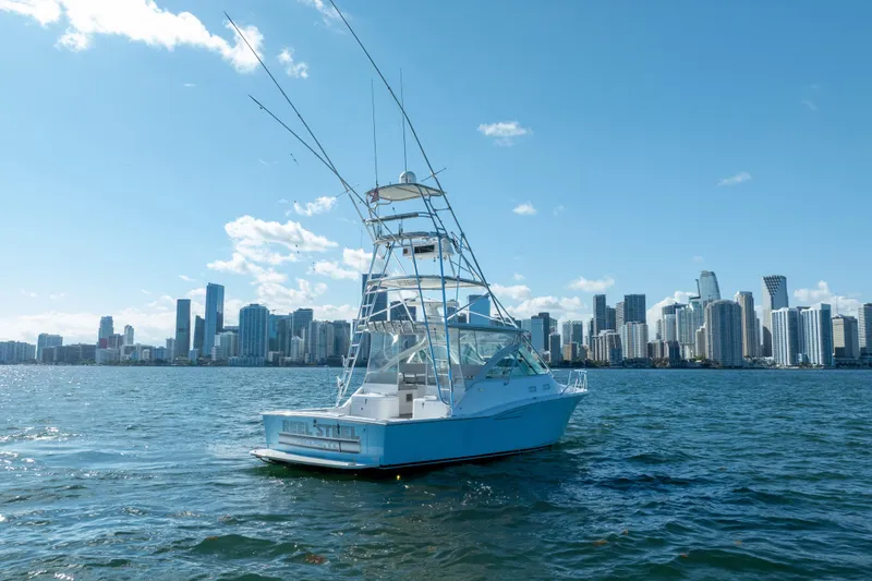 Reel Steel Yacht Photos Pics 2004 Cabo 35 Express boat on water with city skyline in background.