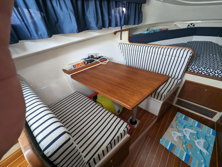 Boatanicals Yacht Photos Pics 2016 Stamas Aegean boat interior with striped seating, wooden table, and nautical decor.