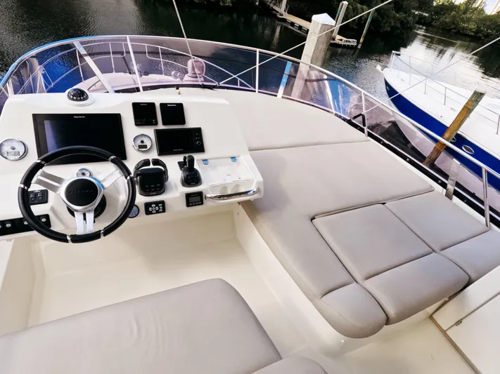  Yacht Photos Pics Prestige 460 yacht helm with modern controls and seating, docked by the water.