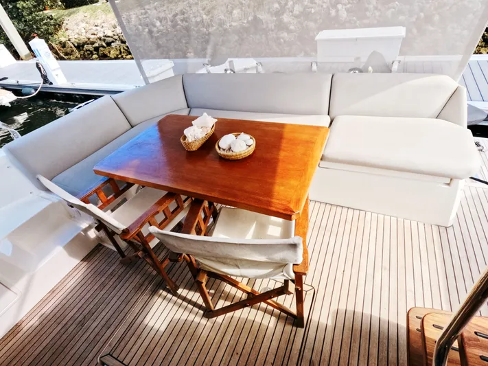 Yacht Photos Pics Luxury seating area on 2020 Prestige 460 yacht with wooden table and cushioned benches.