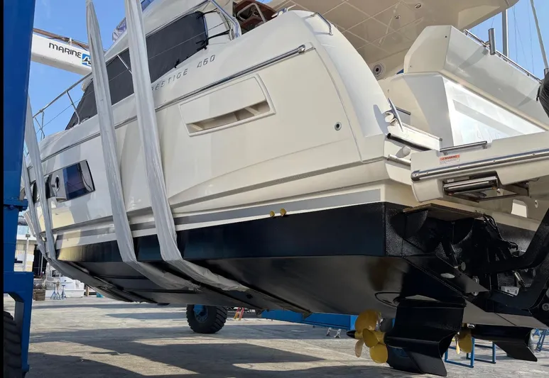  Yacht Photos Pics Prestige 460 yacht, 2020 model, in dry dock for maintenance, showcasing hull and propellers.