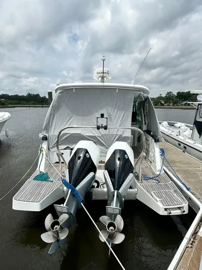 De-sea Yacht Photos Pics 2021 Beneteau GT 32 boat docked, featuring dual outboard motors, under a cloudy sky.