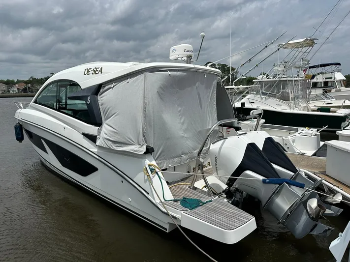 De-sea Yacht Photos Pics 2021 Beneteau GT 32 boat docked, covered stern, overcast sky, marina setting.