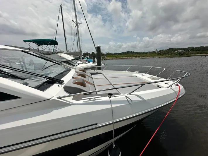 De-sea Yacht Photos Pics 2021 Beneteau GT 32 yacht docked on a calm river under cloudy skies.