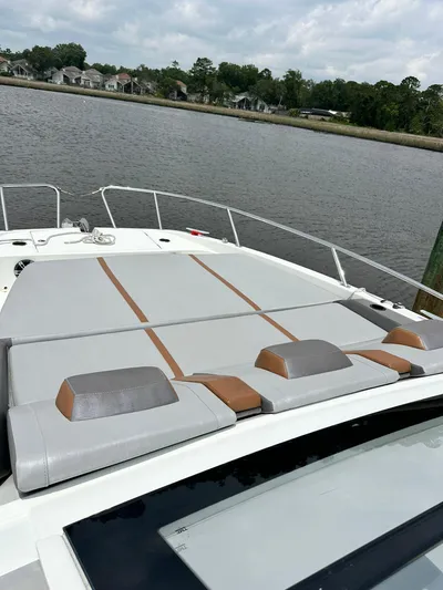 De-sea Yacht Photos Pics 2021 Beneteau GT 32 boat with spacious sunbathing deck, docked by a serene waterfront.