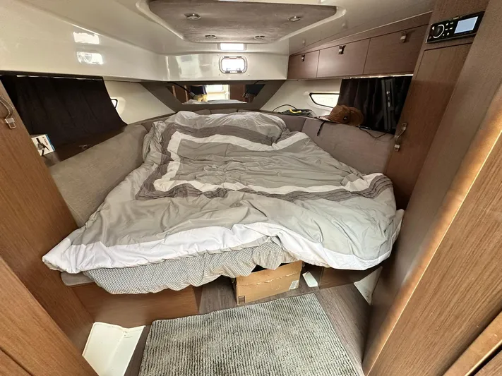 De-sea Yacht Photos Pics Cozy cabin interior of 2021 Beneteau GT 32 with unmade bed and wooden finishes.