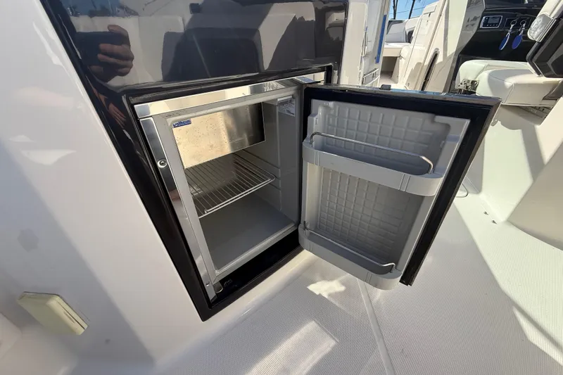  Yacht Photos Pics Open mini fridge on 2014 Monterey 328SS Super Sport boat, showcasing interior storage space.