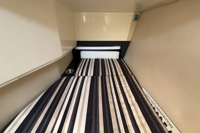  Yacht Photos Pics 2014 Monterey 328SS Super Sport cabin interior with striped bedding and storage space.
