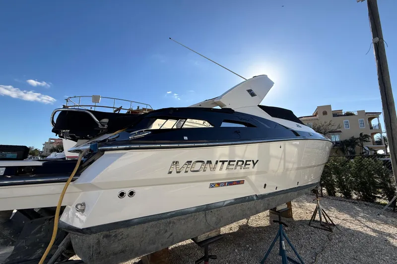  Yacht Photos Pics 2014 Monterey 328SS Super Sport boat on stands, sunlit, with clear blue sky background.