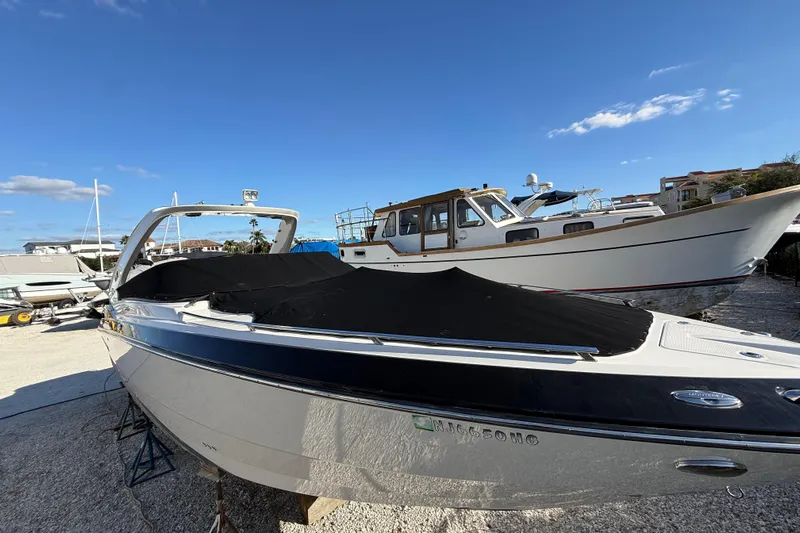  Yacht Photos Pics 2014 Monterey 328SS Super Sport boat with cover, docked under clear blue sky.
