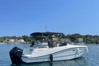 2020 Quicksilver Activ 755 Sundeck boat on calm water under clear blue sky.