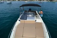 2020 Quicksilver Activ 755 Sundeck boat on calm water, with sunbathing area and canopy.