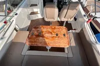 2020 Quicksilver Activ 755 Sundeck boat interior with seating and wooden table.