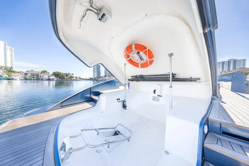 Salt Escape Yacht Photos Pics 2021 Solaris Power 48 OPEN yacht interior with life preserver, docked by waterfront buildings.