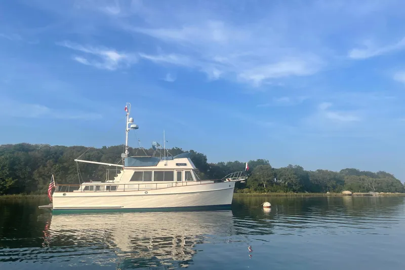 Sea Fever Yacht Photos Pics 1985 Grand Banks 42 Classic yacht on calm water with scenic forest backdrop.