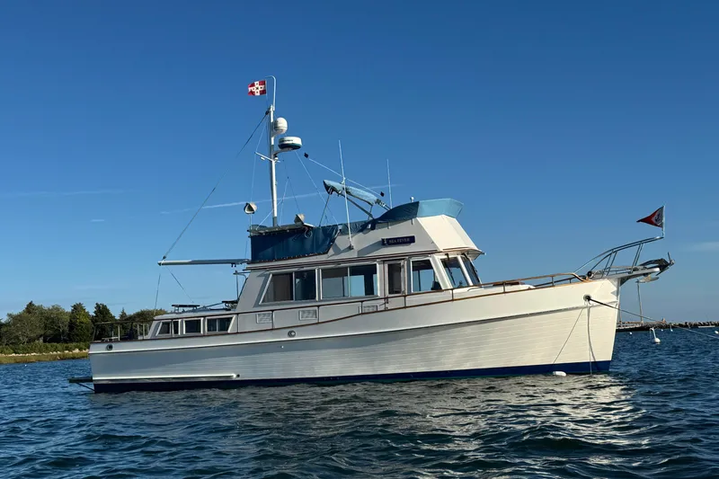 Sea Fever Yacht Photos Pics 1985 Grand Banks 42 Classic yacht on calm water under clear blue sky.