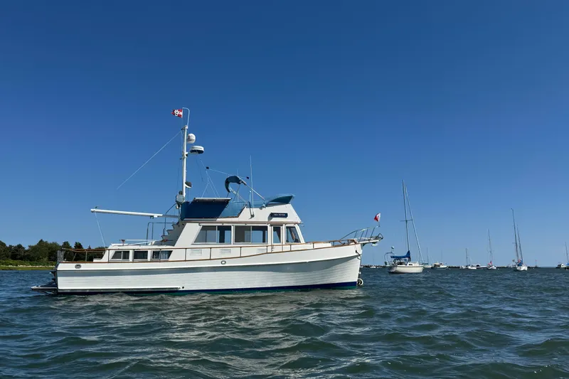 Sea Fever Yacht Photos Pics 1985 Grand Banks 42 Classic yacht on calm water under clear blue sky.
