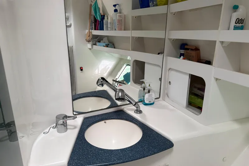  Yacht Photos Pics Bathroom sink area on 2003 Fountaine Pajot Belize 43 catamaran with storage shelves and mirror.