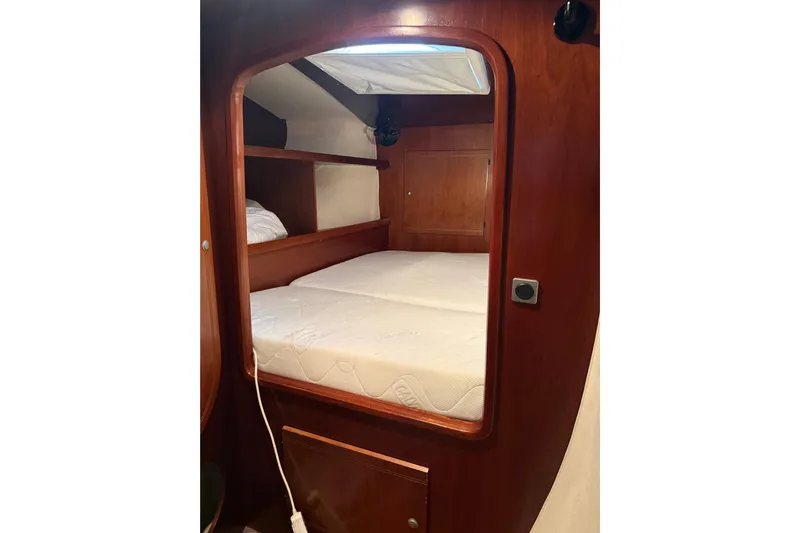  Yacht Photos Pics Cabin interior of 2003 Fountaine Pajot Belize 43 with wooden finish and cozy bed.