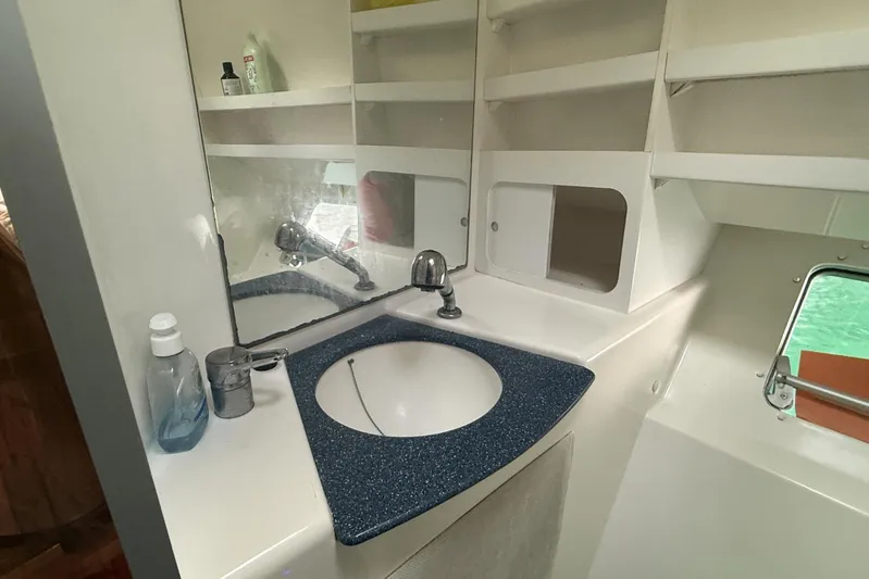  Yacht Photos Pics Bathroom sink area in 2003 Fountaine Pajot Belize 43 catamaran with mirror and storage shelves.