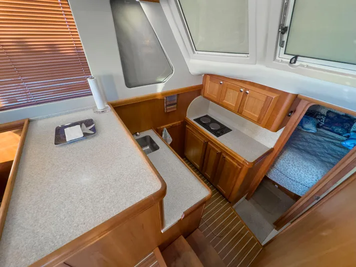Vitamin Sea Yacht Photos Pics 2005 Mainship 34 Trawler interior kitchen with wood cabinetry and compact design.