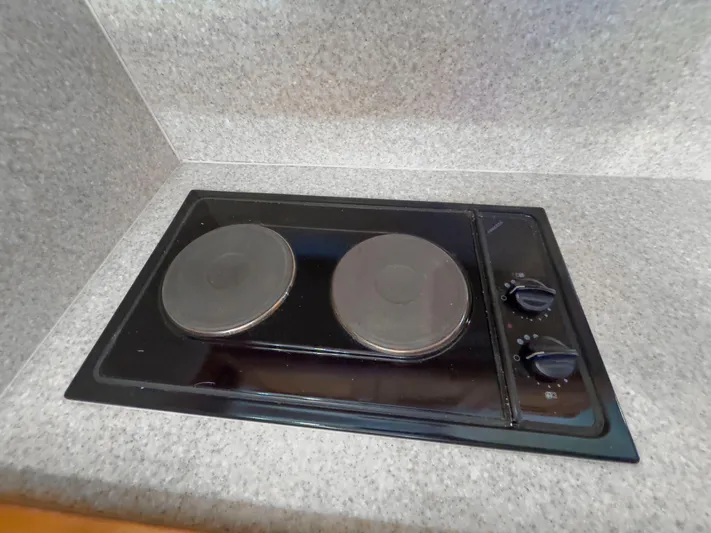 Vitamin Sea Yacht Photos Pics Electric stove in 2005 Mainship 34 Trawler kitchen, featuring dual burners and control knobs.