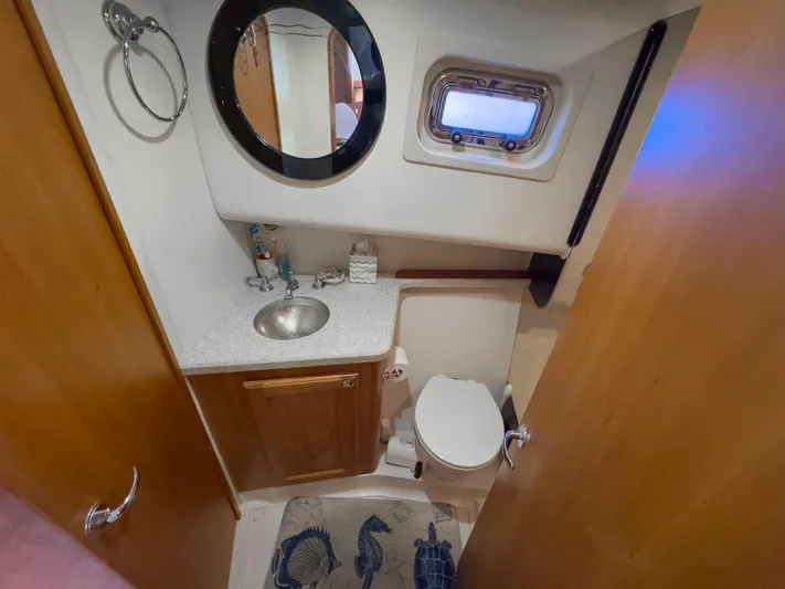 Vitamin Sea Yacht Photos Pics 2005 Mainship 34 Trawler bathroom with sink, mirror, and porthole window.