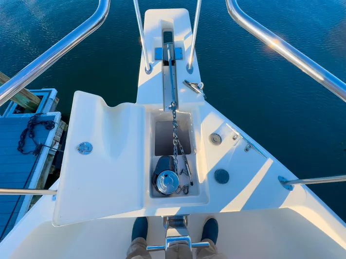 Vitamin Sea Yacht Photos Pics Mainship 34 Trawler 2005 bow with anchor chain and railing, docked on calm water.