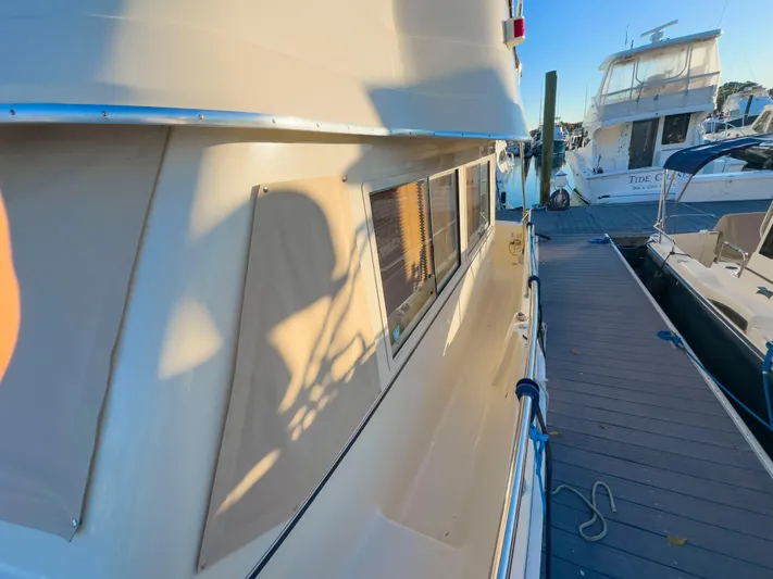 Vitamin Sea Yacht Photos Pics 2005 Mainship 34 Trawler docked at marina, side view with shadow.