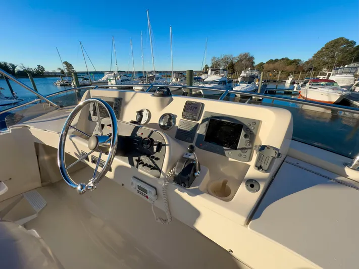 Vitamin Sea Yacht Photos Pics 2005 Mainship 34 Trawler helm with navigational instruments, docked at marina.