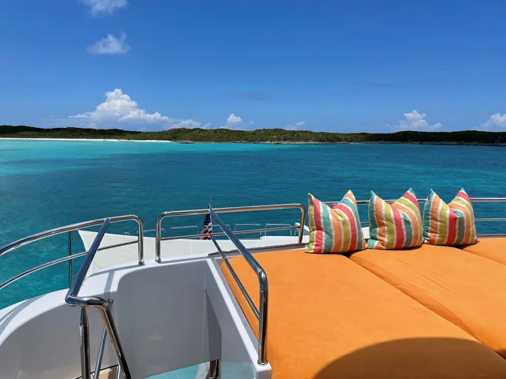Relentless Yacht Photos Pics Westport Tri-Deck Motoryacht 2006 with sun deck and cushions, overlooking tropical sea.