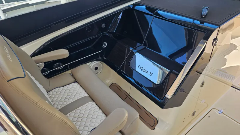  Yacht Photos Pics 2022 Chris-Craft Calypso 35 interior with beige seating and sleek black dashboard.