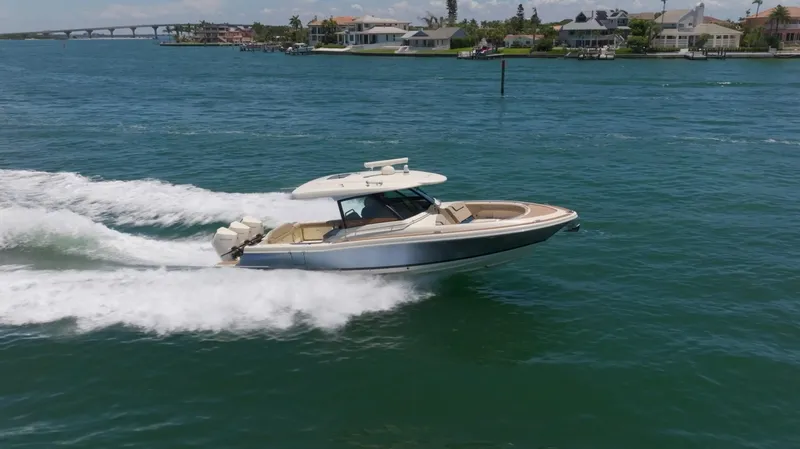  Yacht Photos Pics 2022 Chris-Craft Calypso 35 cruising on blue water near coastal homes.