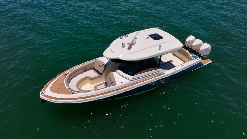  Yacht Photos Pics 2022 Chris-Craft Calypso 35 boat on open water, featuring sleek design and triple outboard engines.