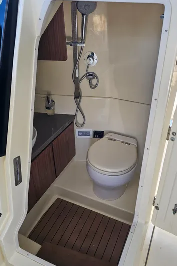  Yacht Photos Pics 2022 Chris-Craft Calypso 35 boat bathroom with shower, toilet, and wooden flooring.