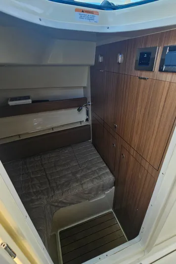  Yacht Photos Pics 2022 Chris-Craft Calypso 35 cabin interior with wood paneling and cozy bed.