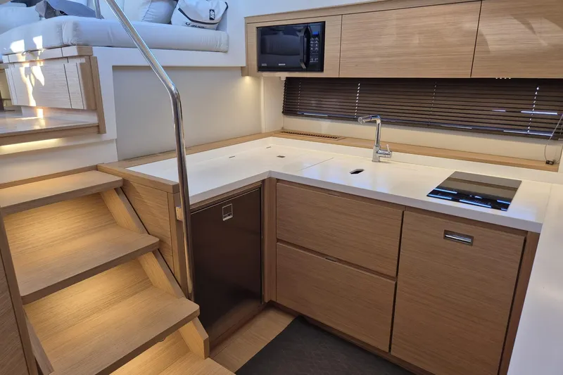  Yacht Photos Pics Modern kitchen interior of 2023 Pardo Yachts GT52, featuring sleek wood cabinetry and appliances.