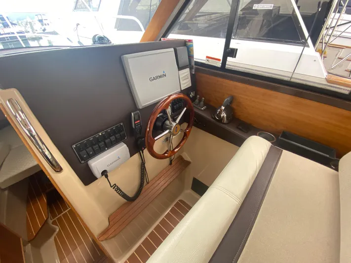  Yacht Photos Pics Interior helm of 2015 Cutwater C-28 boat with Garmin navigation system and wooden steering wheel.