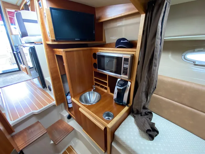  Yacht Photos Pics Interior of 2015 Cutwater C-28 boat with kitchenette, TV, and seating area.