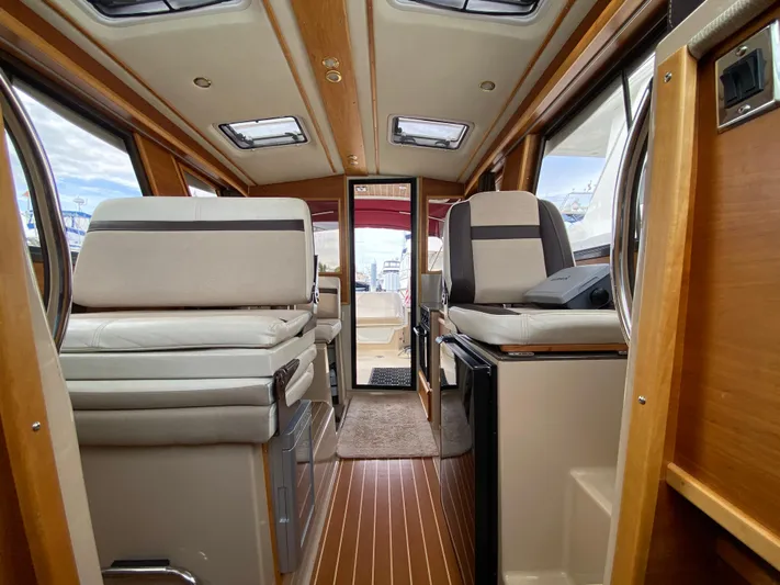 Yacht Photos Pics Interior of a 2015 Cutwater C-28 boat, featuring wood accents and comfortable seating.