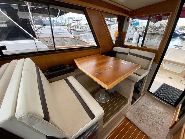  Yacht Photos Pics Interior of a 2015 Cutwater C-28 boat with seating and wooden table.