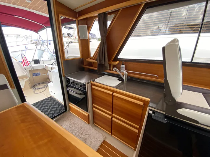  Yacht Photos Pics Interior of 2015 Cutwater C-28 boat with wood cabinetry and compact kitchen area.